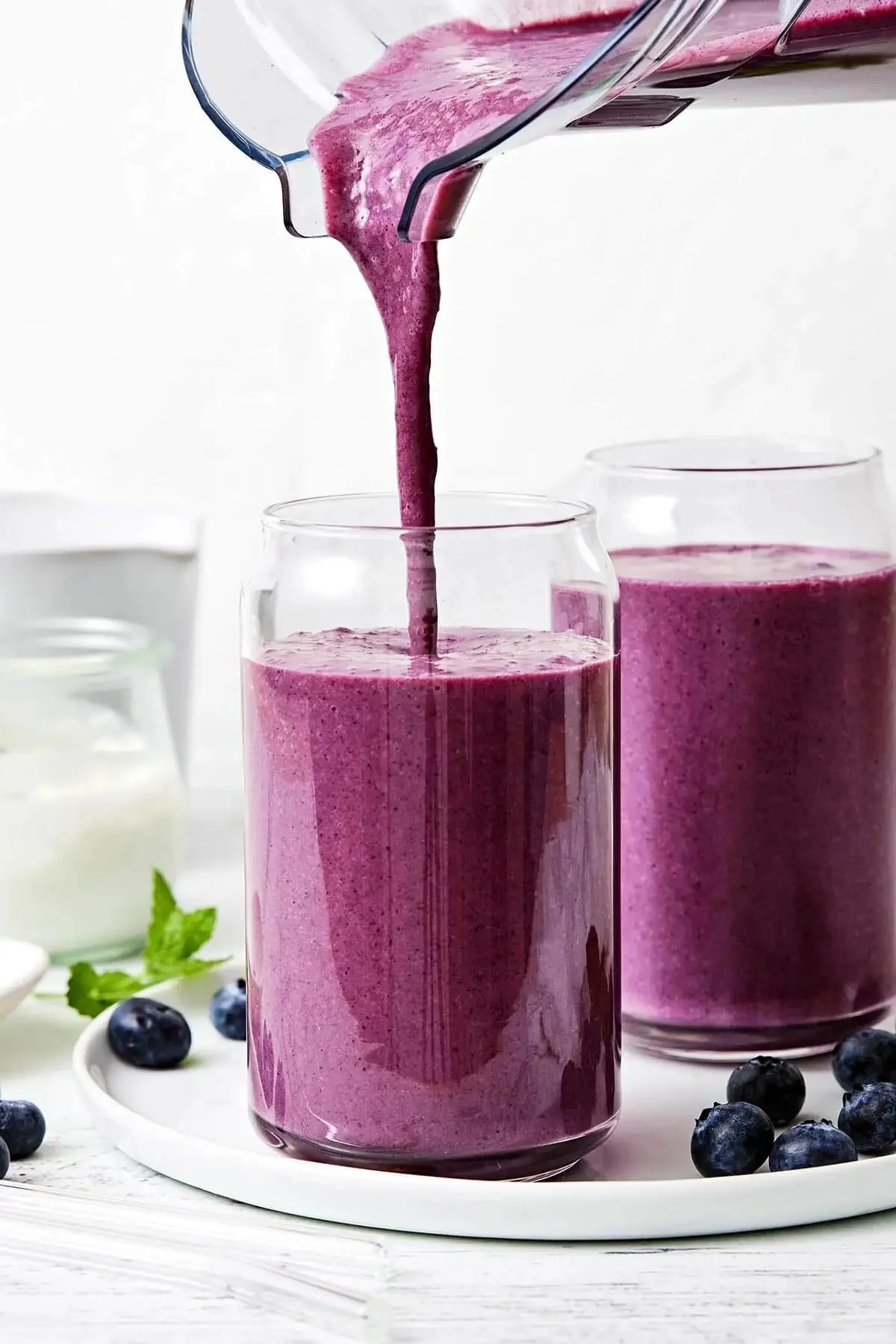 Smoothie aux bleuets servi dans un verre avec des fruits frais