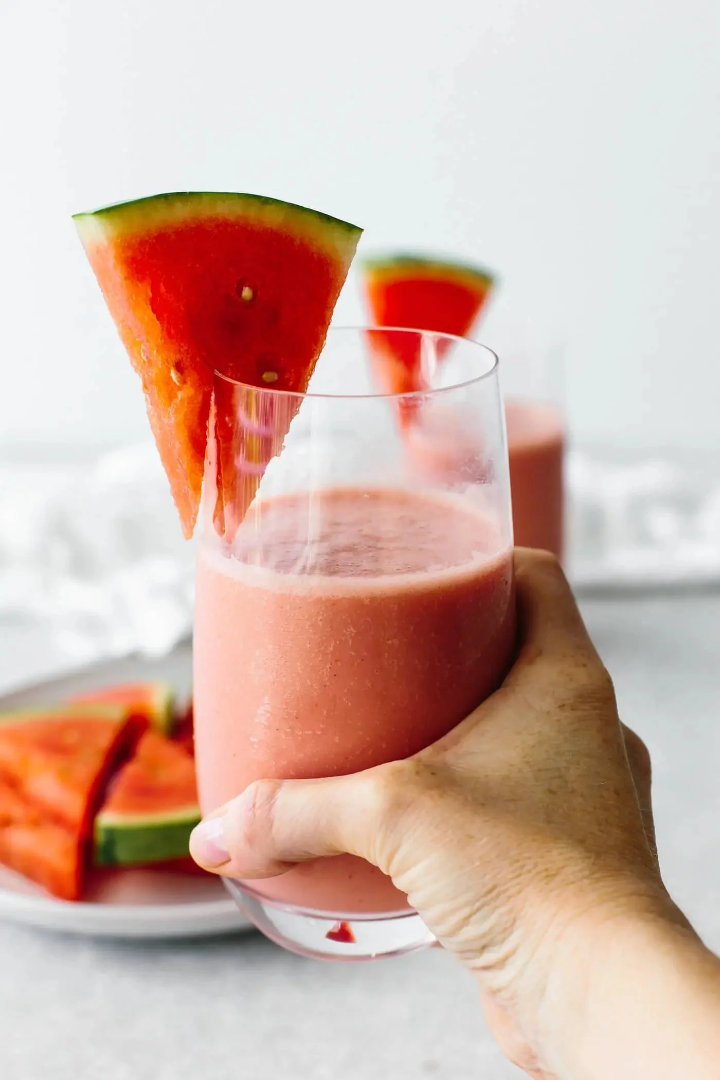 Smoothie rafraîchissant à la pastèque dans un verre avec des morceaux de fruit