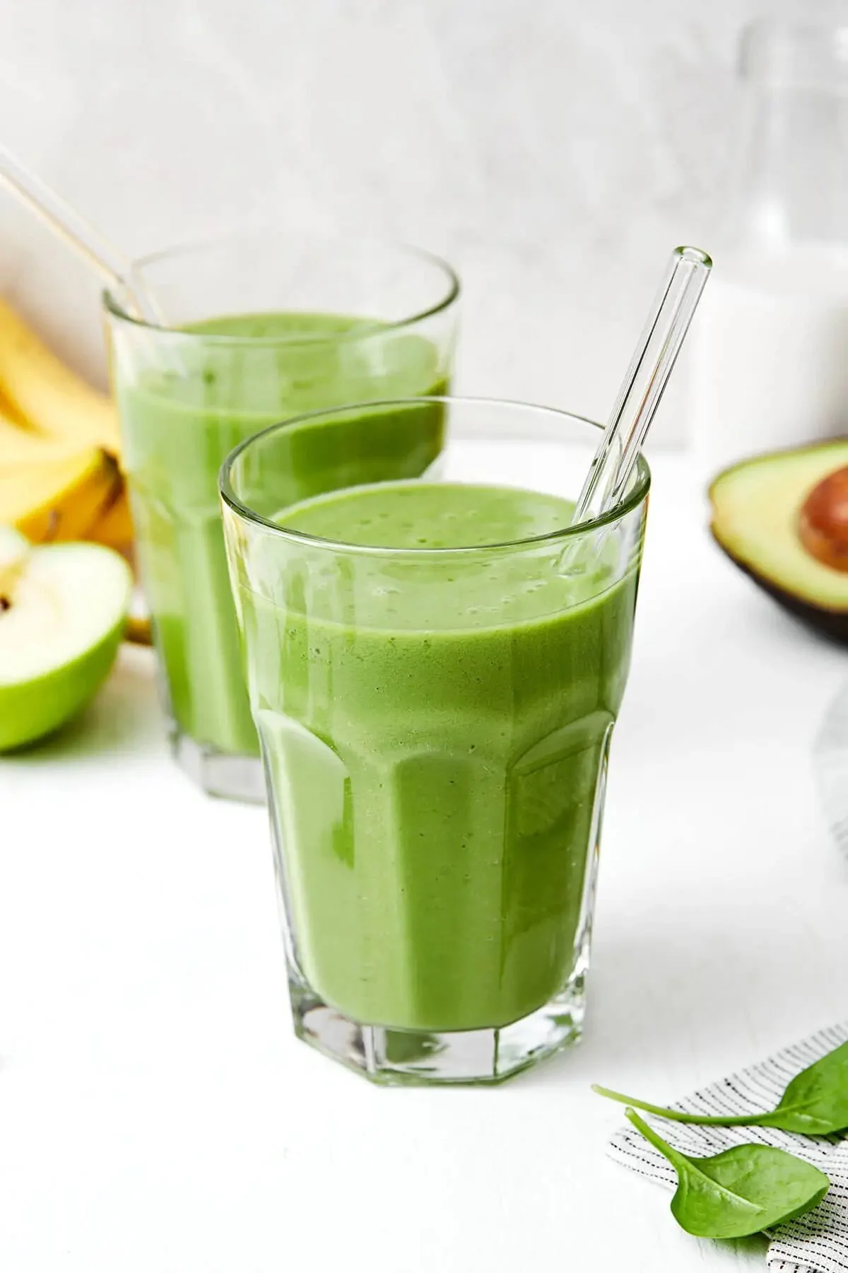 Un smoothie vert sain et nutritif dans un verre sur une table en bois.